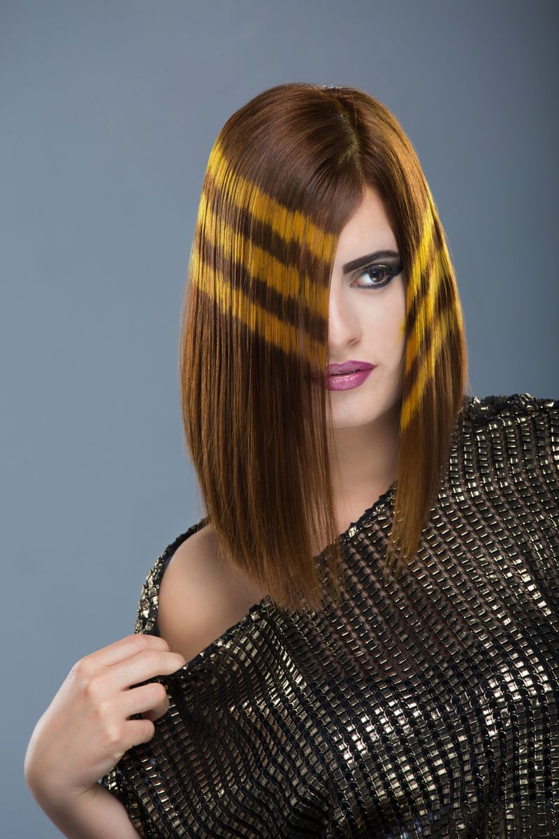 Portrait of a woman showcasing a unique hairstyle and bold makeup.